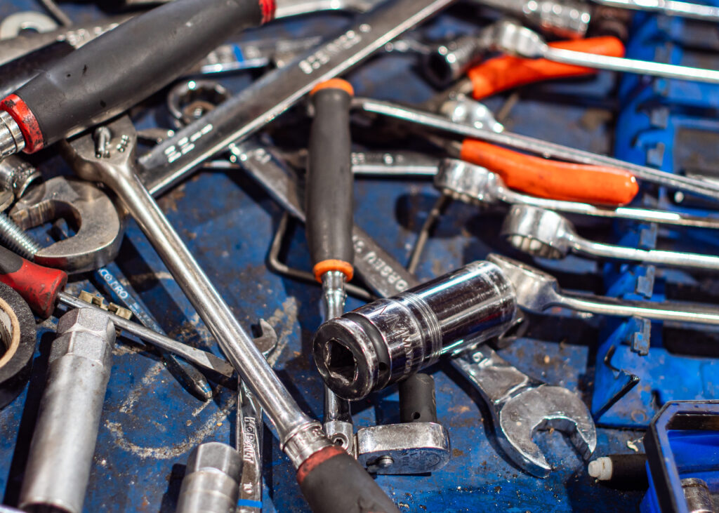 Crescent wrenches and socket wrenches are spread over a blue tool box.